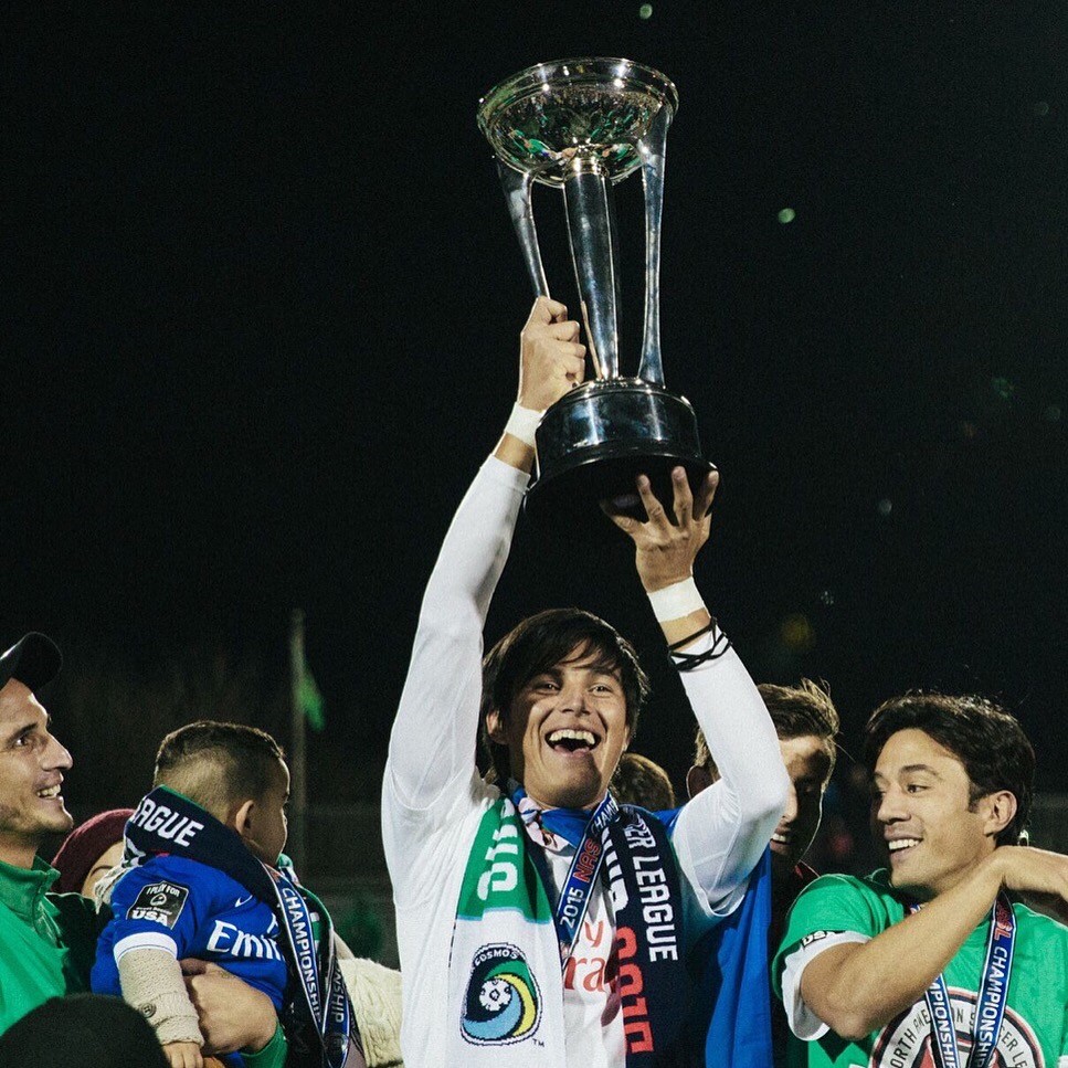 Samuel Caceres raising a trophy with teammates